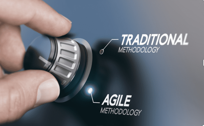 A hand turning a knob from Traditional to Agile.