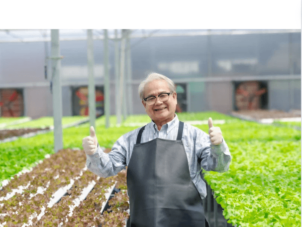 A man in an apron giving two thumbs up.