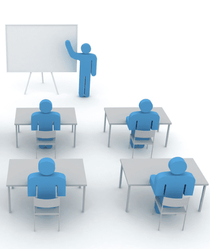 A group of people sitting at desks in front of a whiteboard.